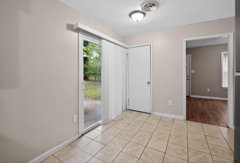 Sliding glass door leading to the exterior, complemented by vertical blinds