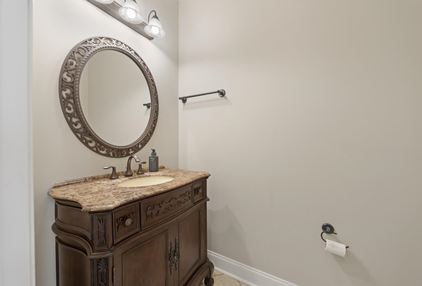 Ornate vanity with a granite countertop and oval undermount sink