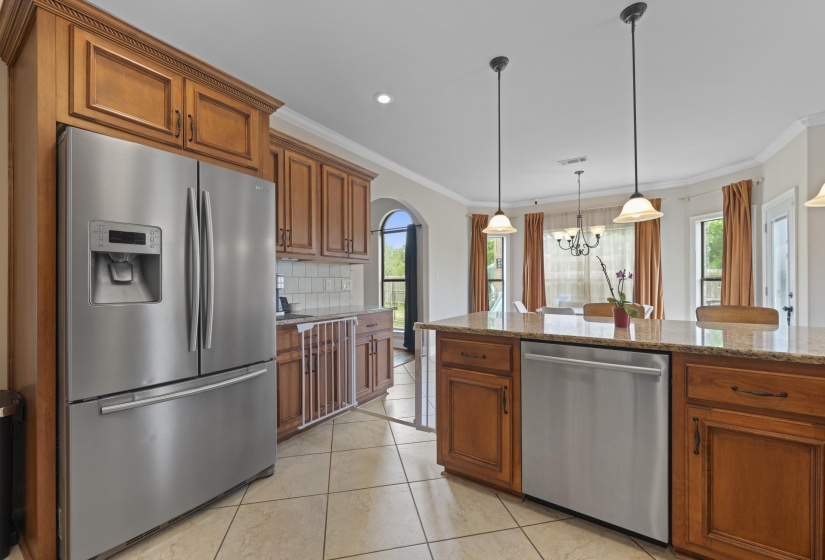 Kitchen featuring a stainless steel French door refrigerator, wood cabinetry, stone countertops, and a tile backsplash