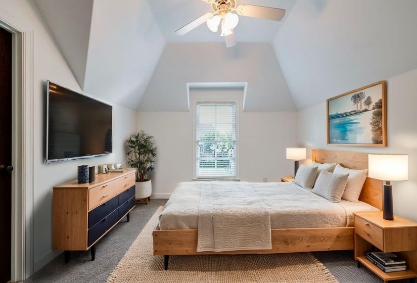 Carpeted bedroom with lofted ceiling and ceiling fan