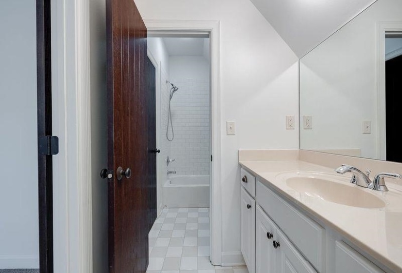 Bathroom with tiled shower / bath, vanity, and tile patterned flooring