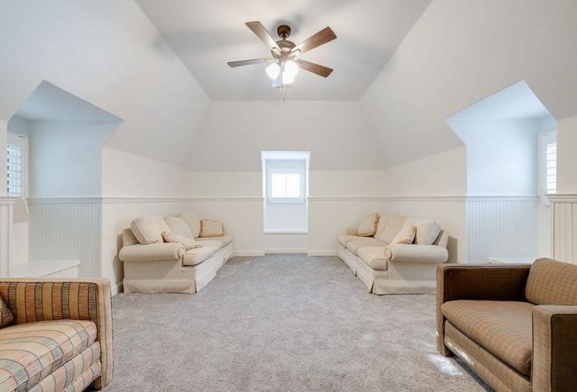 Bonus room with light carpet, ceiling fan, and vaulted ceiling