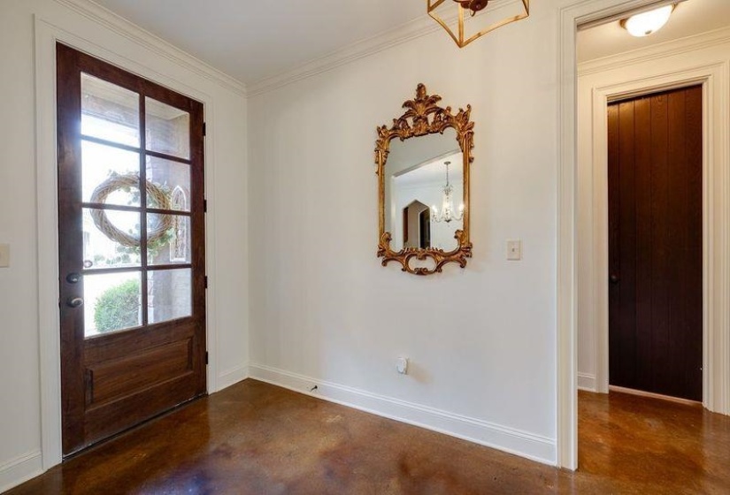 Entryway with an inviting chandelier and crown molding