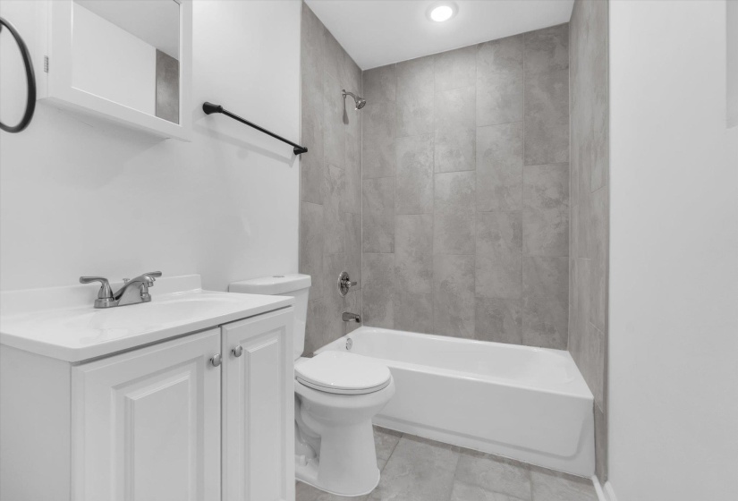 Bathroom featuring a white vanity with integrated sink, chrome faucet, and cabinet storage