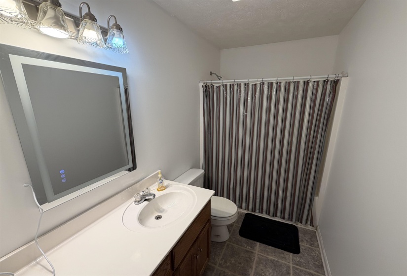 Bathroom with vanity, a shower with curtain, and a textured ceiling