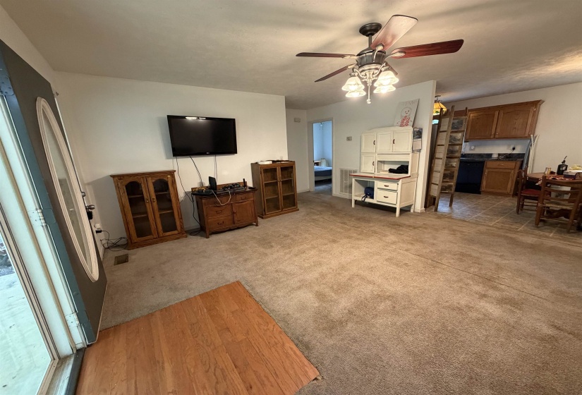 Living room featuring ceiling fan, light wood-type flooring, and light colored carpet