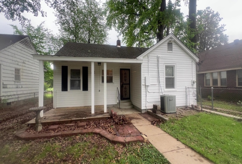 White siding exterior with a covered porch featuring white pillars and a dark roof