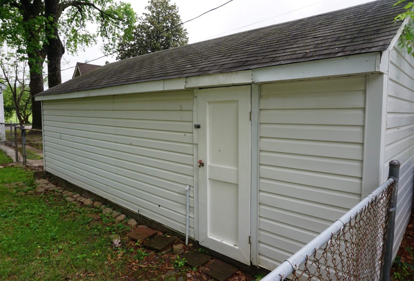 Detached garage with horizontal siding and an asphalt shingle roof