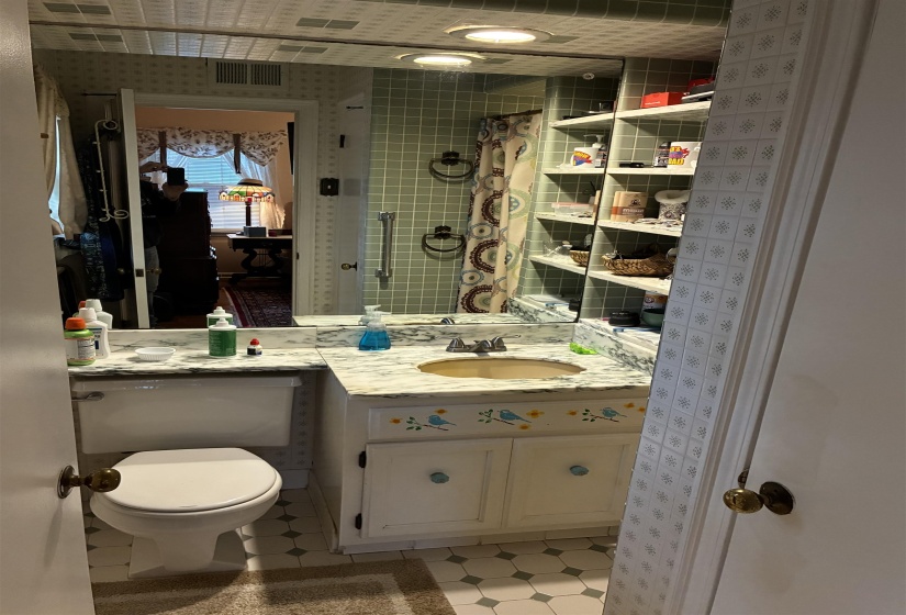 Bathroom featuring a vanity with a drop-in sink and a patterned countertop