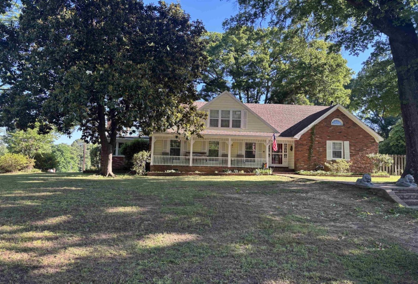 Traditional home featuring a brick and siding facade with a covered front porch