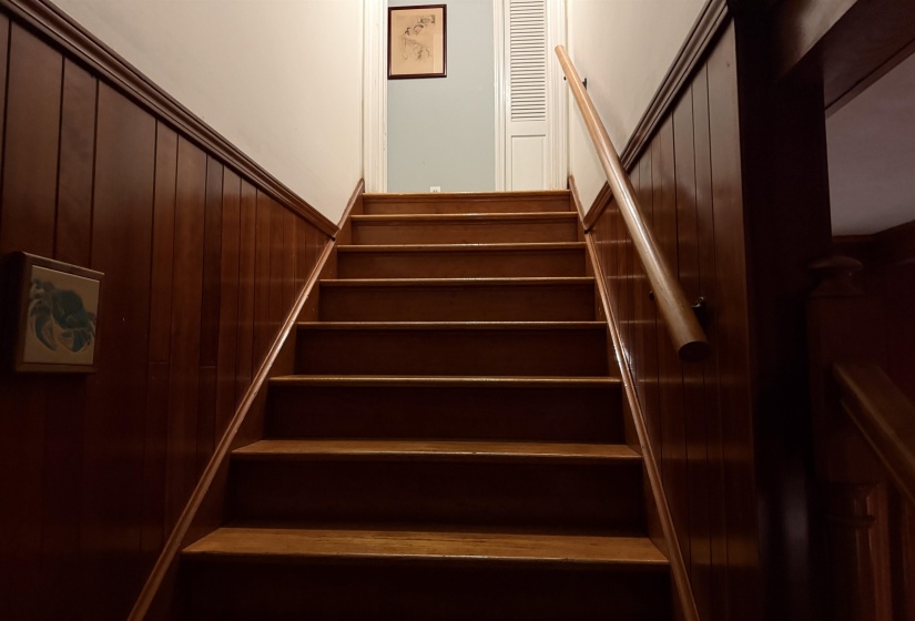 Hardwood staircase with a natural finish, complemented by a wooden handrail