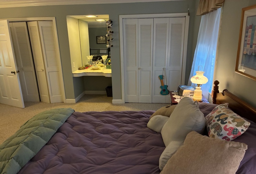 Built-in vanity with integrated mirror, flanked by dual bi-fold louvered closet doors