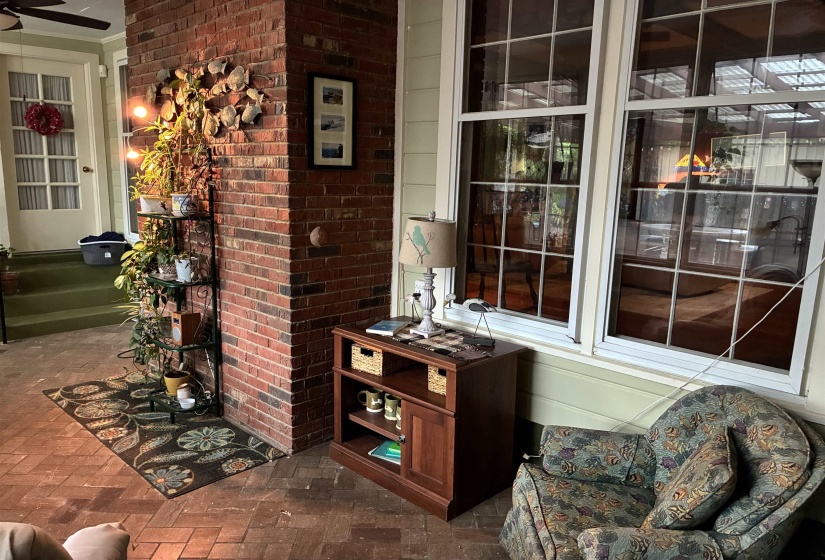 Interior brick wall accentuating a sunroom with large grid-paned windows