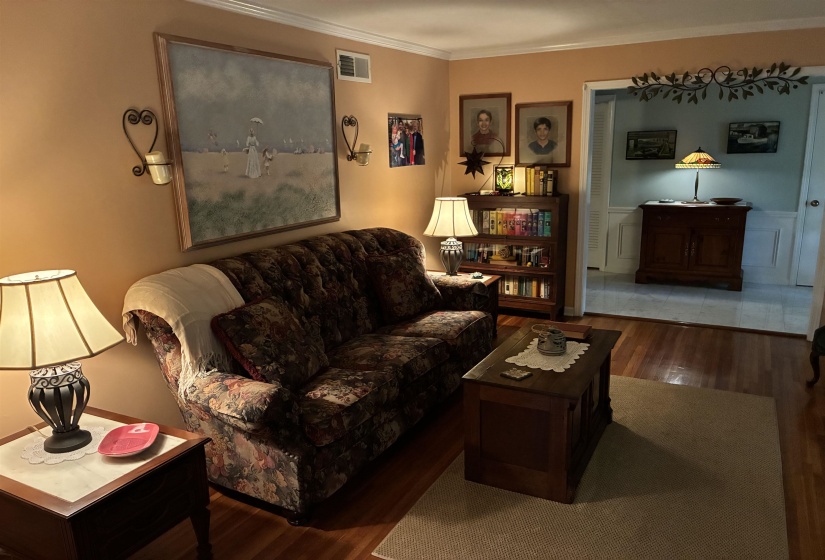 Warm-toned interior featuring wood-finish flooring and crown molding