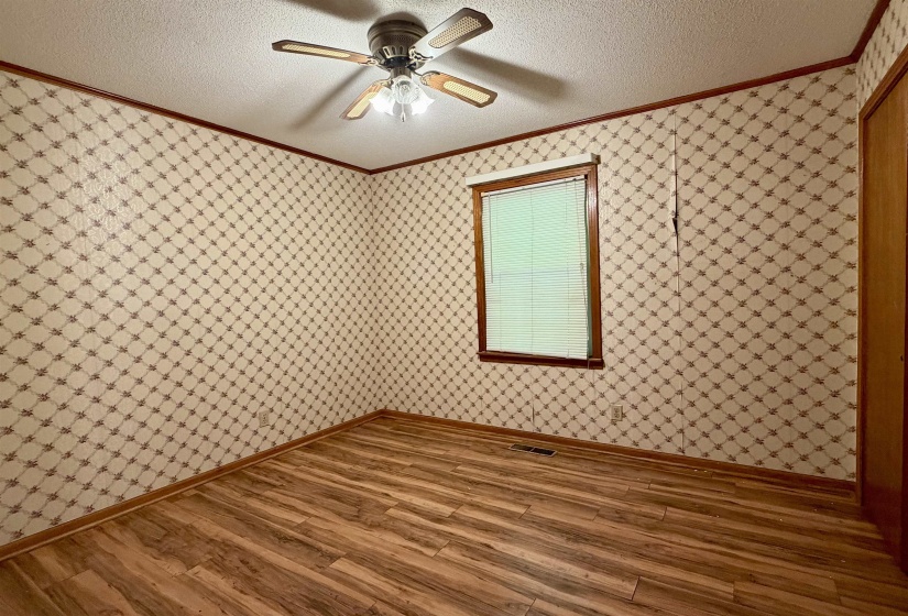 Room featuring wood-finish flooring, a window with blinds, and a ceiling fan with integrated lighting