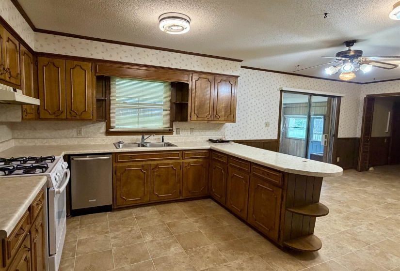 Kitchen featuring wood cabinetry, laminate countertops, and tile flooring