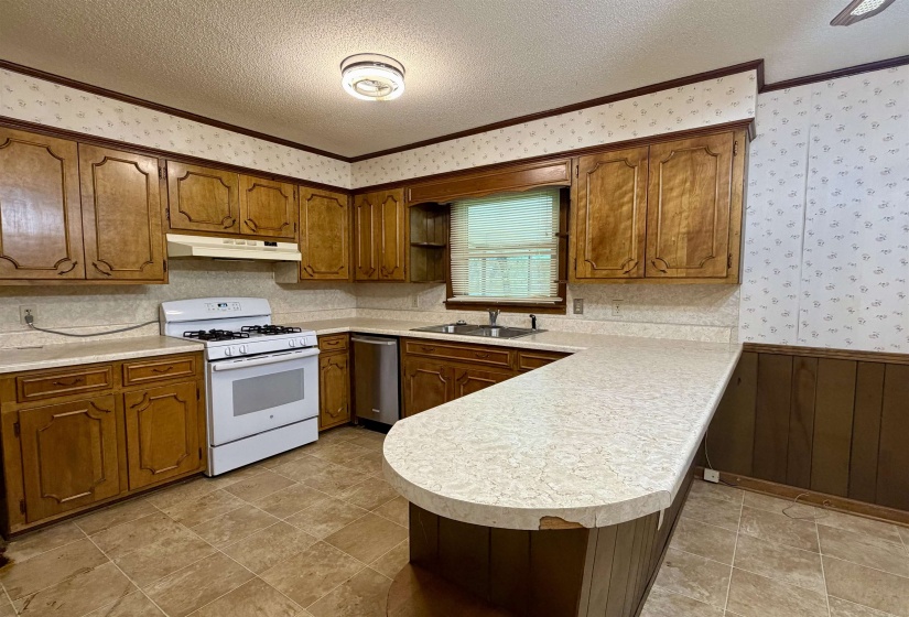 Kitchen with extensive wood cabinetry and light-toned countertops