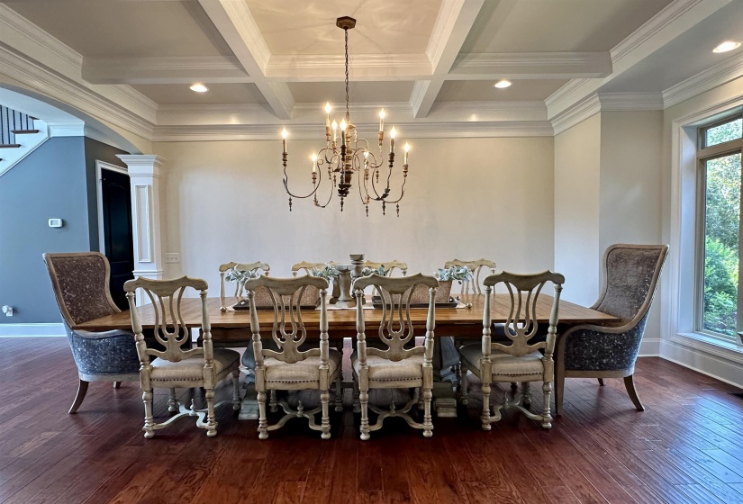 Dining area with dark wood finished floors, beamed ceiling, coffered ceiling, recessed lighting, and decorative columns