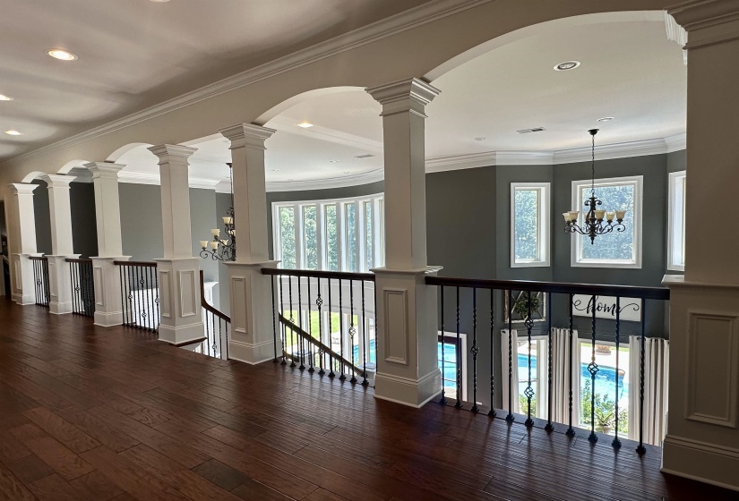 Hall featuring a chandelier, crown molding, dark wood finished floors, recessed lighting, and arched walkways