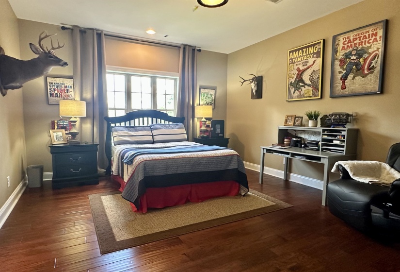 Bedroom with dark wood-style floors and baseboards