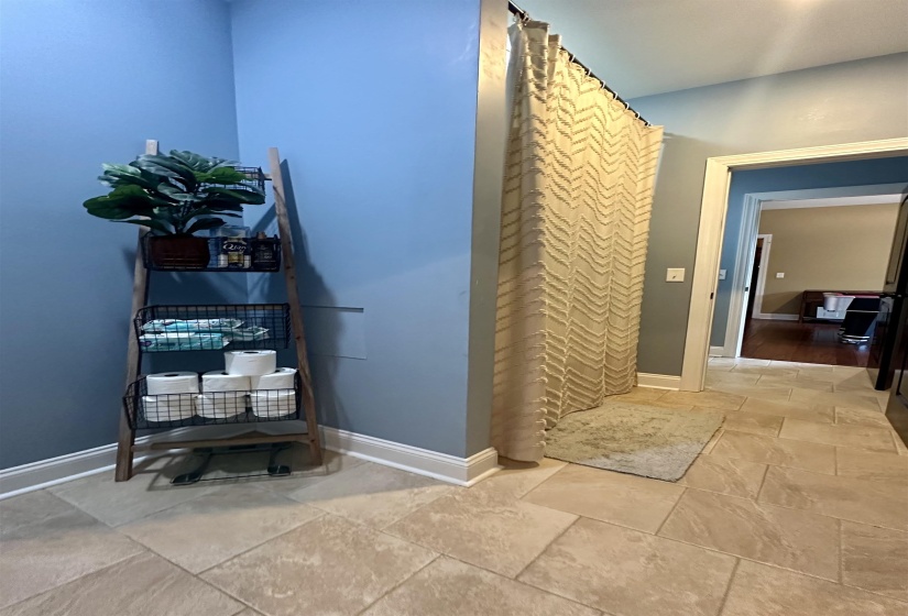 Bathroom with a shower with curtain and stone tile floors