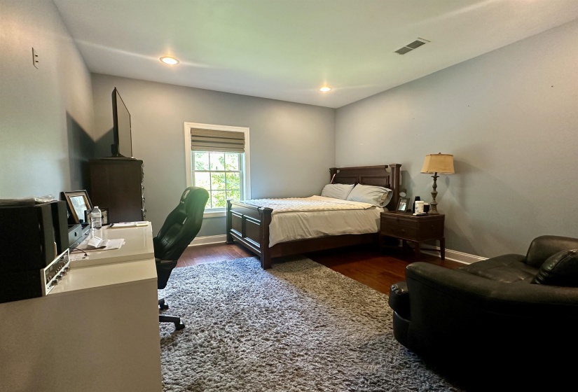 Bedroom with dark wood-type flooring, recessed lighting, and an office area