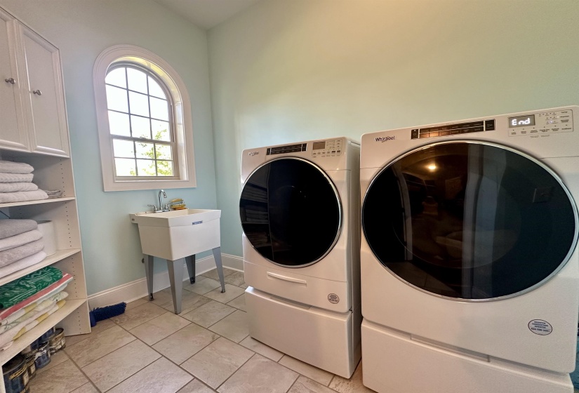 Laundry room with light tile patterned flooring and washing machine and clothes dryer