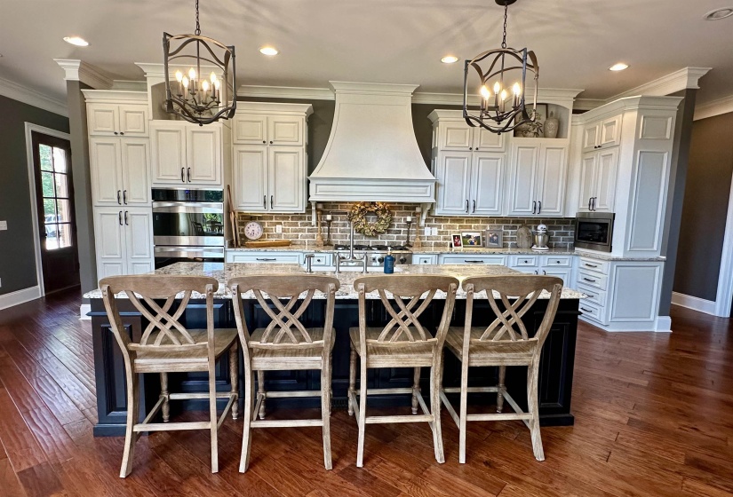 Kitchen with ornamental molding, a chandelier, recessed lighting, backsplash, and a large island
