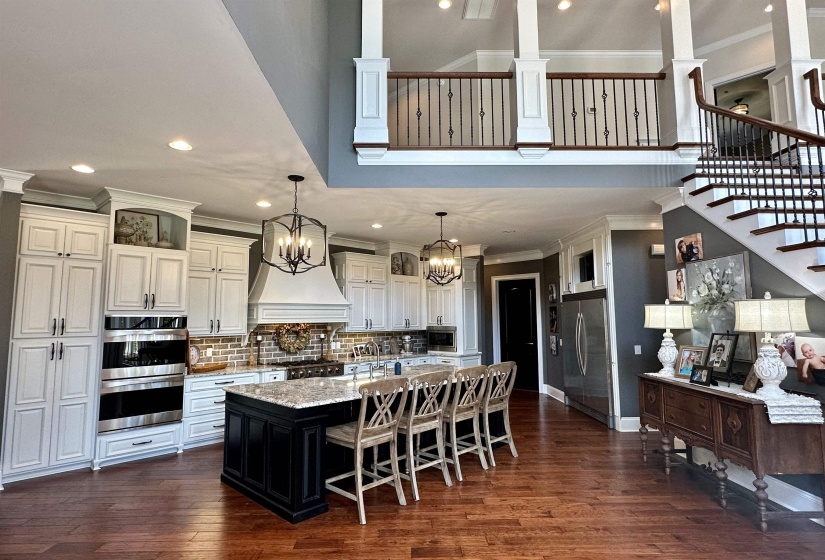 Kitchen featuring crown molding, recessed lighting, pendant lighting, dark cabinetry, and stainless steel appliances