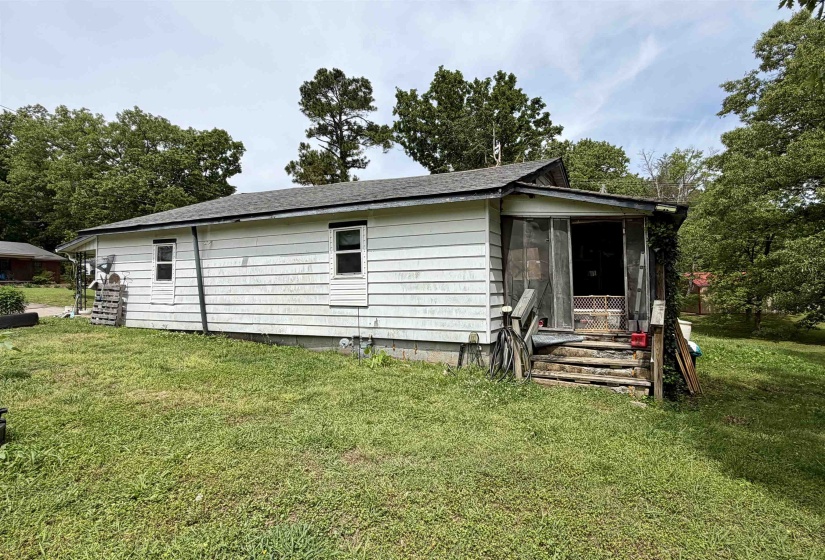 White siding exterior featuring a screened porch entry and a partial gabled roofline