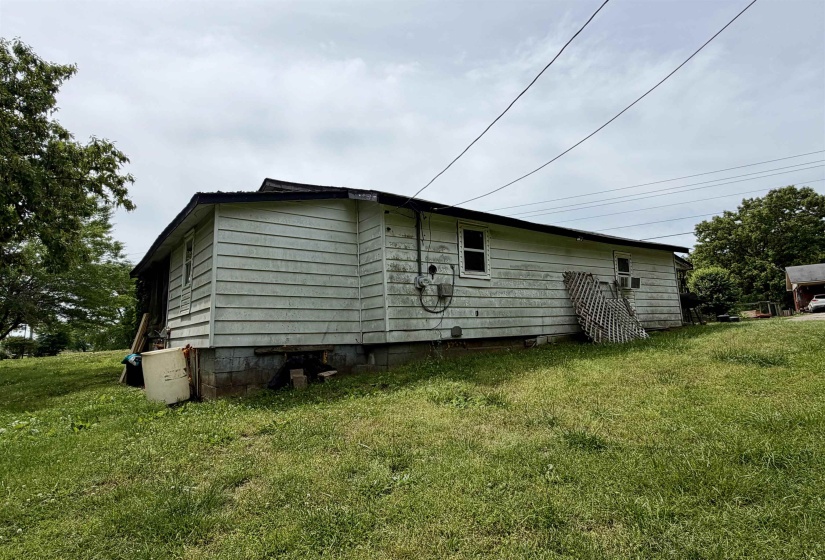 Single-story structure featuring horizontal siding, a dark-toned roof, and multiple windows