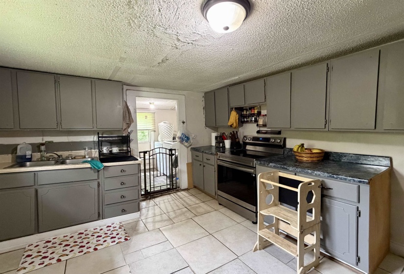 Kitchen with tile flooring and painted cabinetry
