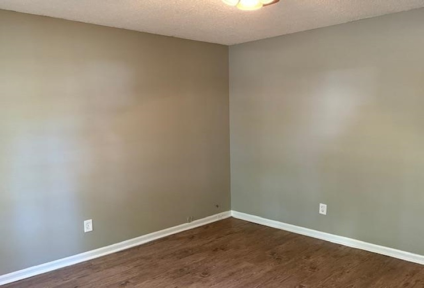 Unfurnished room featuring a textured ceiling and dark hardwood / wood-style floors