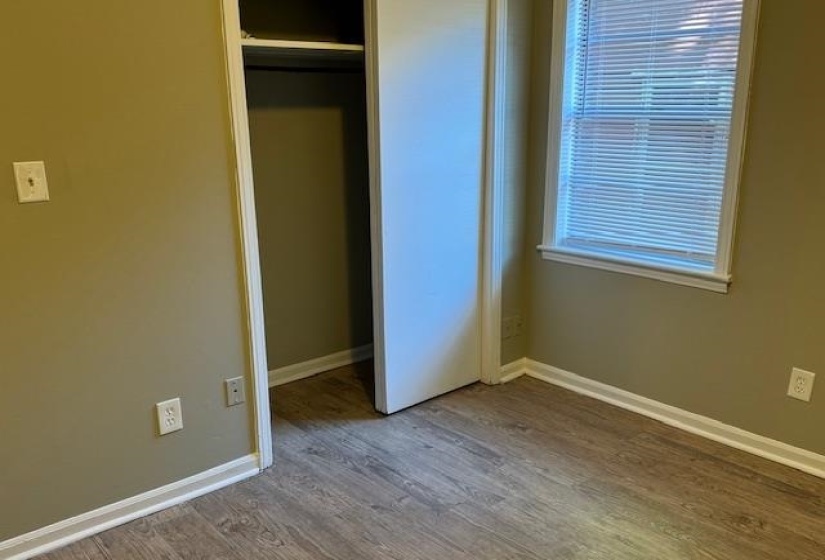 Unfurnished bedroom with wood-type flooring and a closet