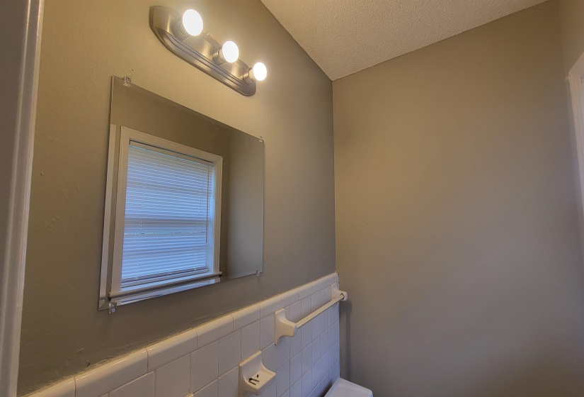 Bathroom featuring tile walls and a textured ceiling