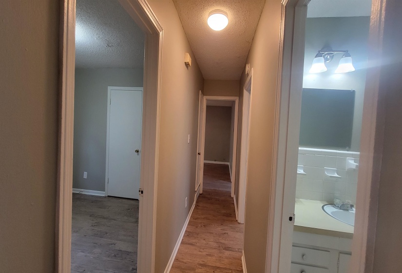 Corridor featuring a textured ceiling and hardwood / wood-style flooring