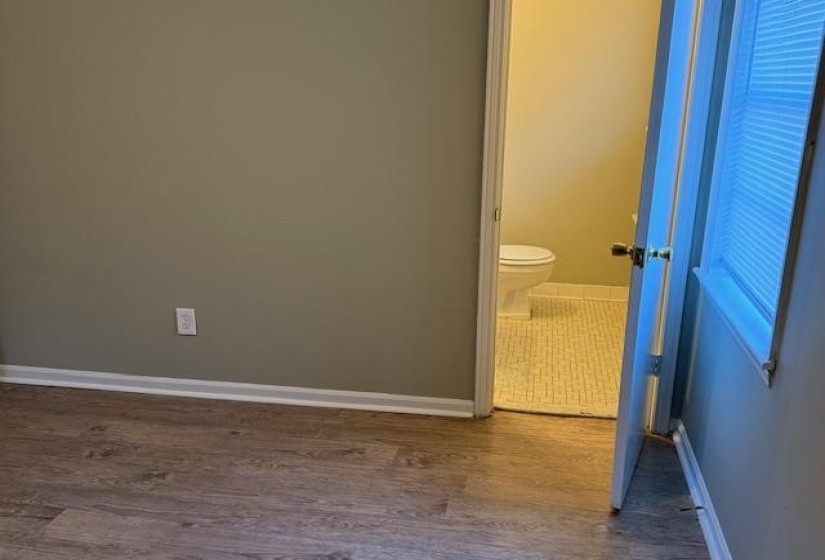 Bathroom with hardwood / wood-style flooring and toilet