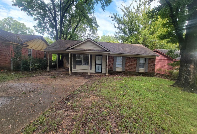 Single story home with a front yard and a carport