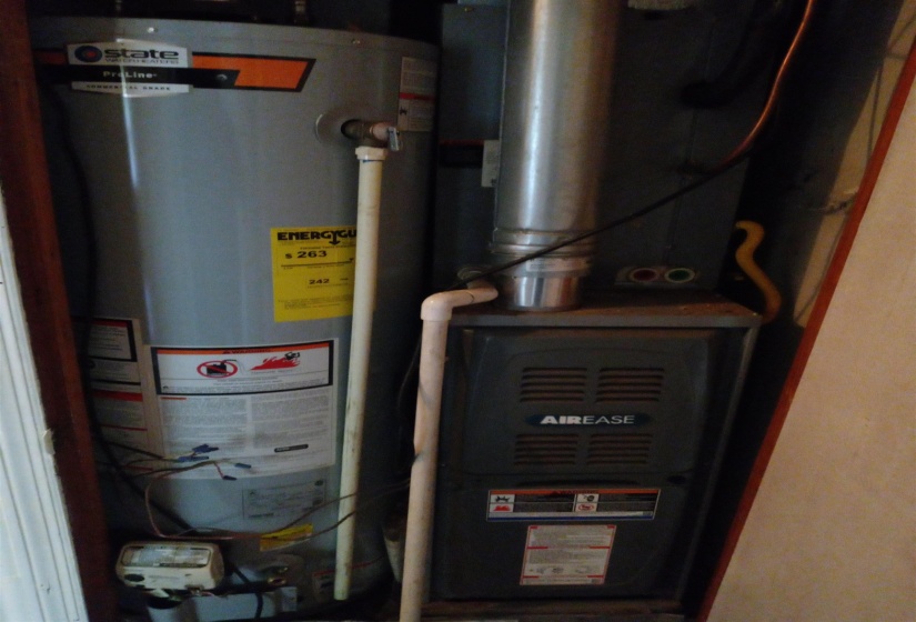 Utility room featuring heating unit and water heater