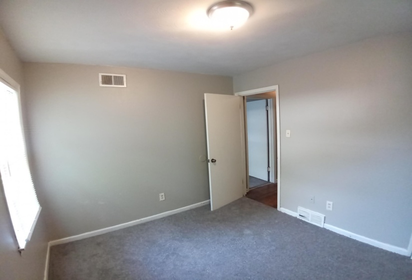 Spare room featuring dark carpet