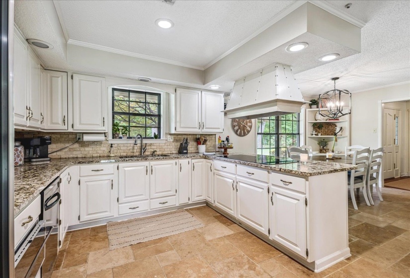 Kitchen featuring white cabinetry, speckled countertops, a tile backsplash, and recessed lighting