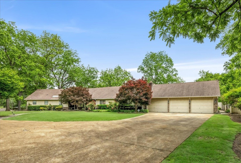 Ranch-style residence featuring a prominent three-car garage with individual doors
