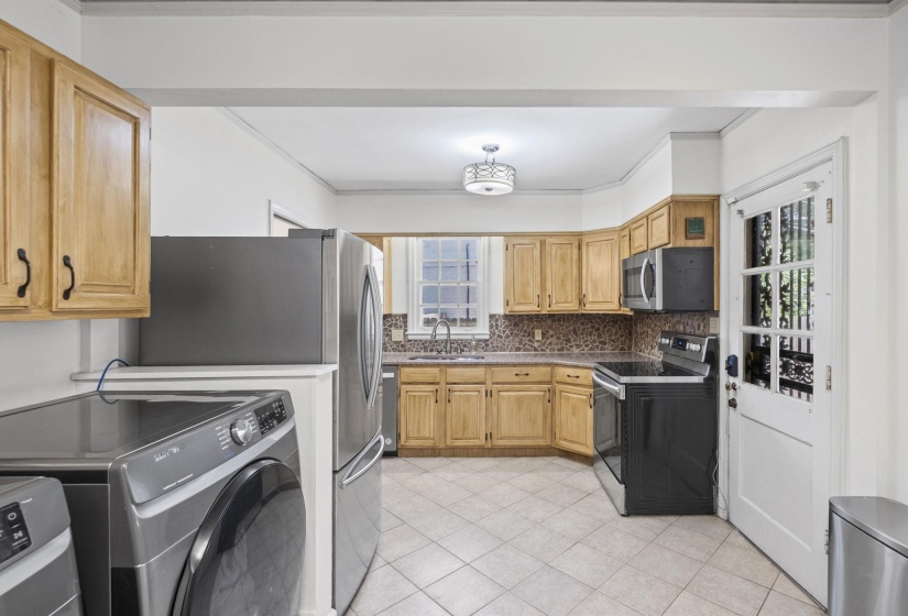 Kitchen featuring wood cabinetry, stainless steel refrigerator, microwave, and range
