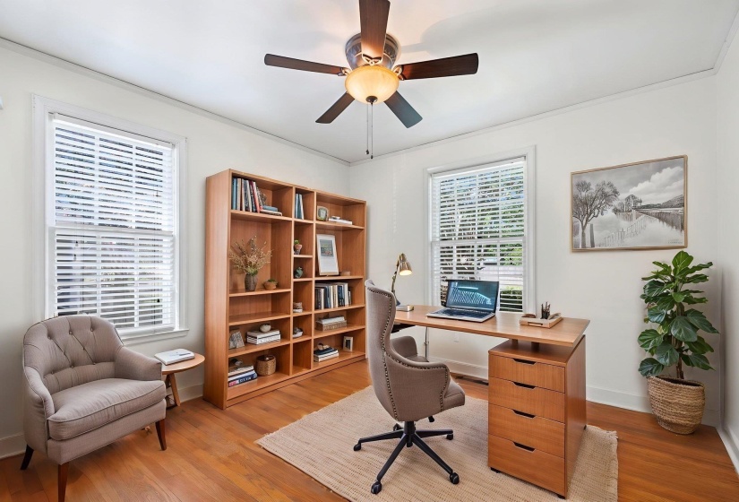 Versatile room featuring wood-finish flooring and two bright windows with blinds