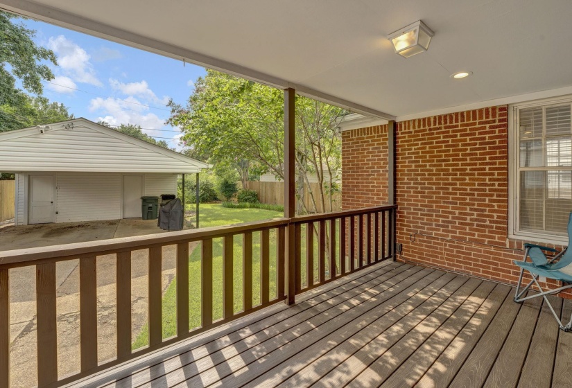 Covered porch featuring wood-finish decking and a wood railing