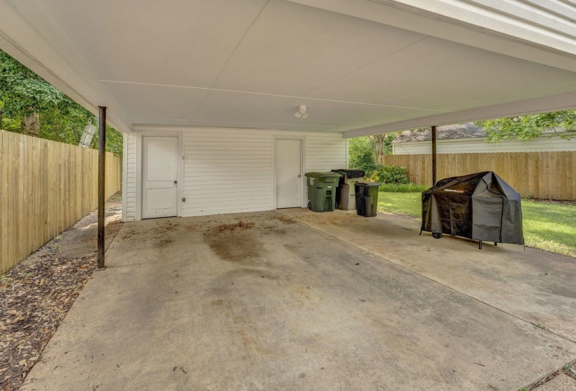 Concrete carport with a white paneled ceiling and exposed support beams