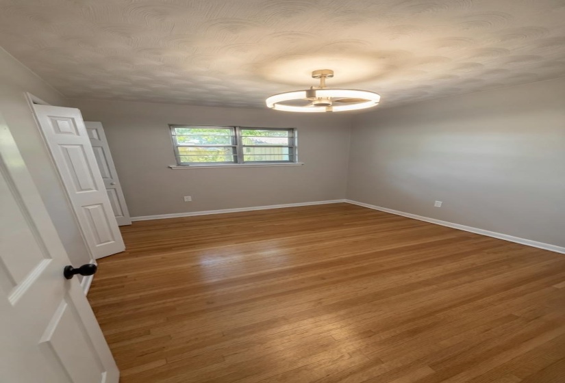 Room featuring wood-finish flooring, light gray wall paint, and white trim