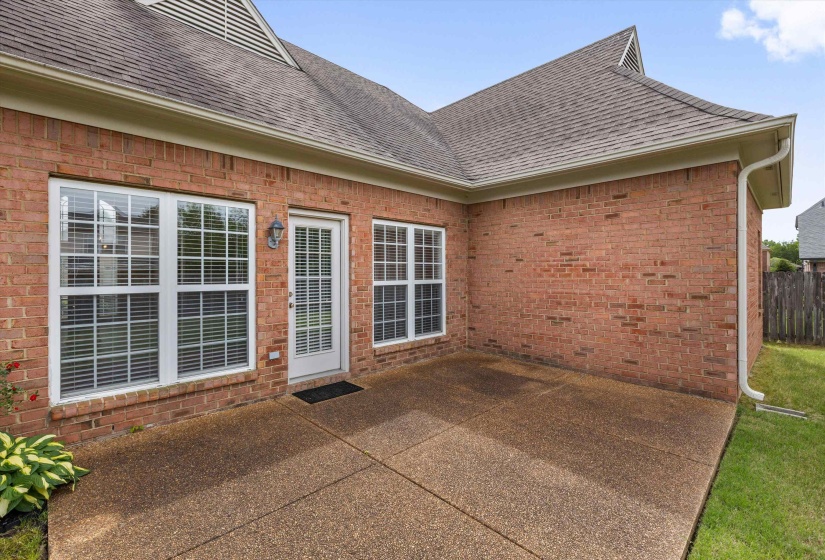 Expansive exposed aggregate patio with a full-light rear door