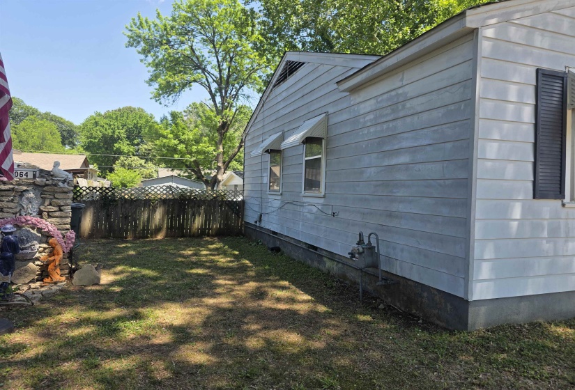 Side exterior of the property featuring horizontal siding and a fenced yard