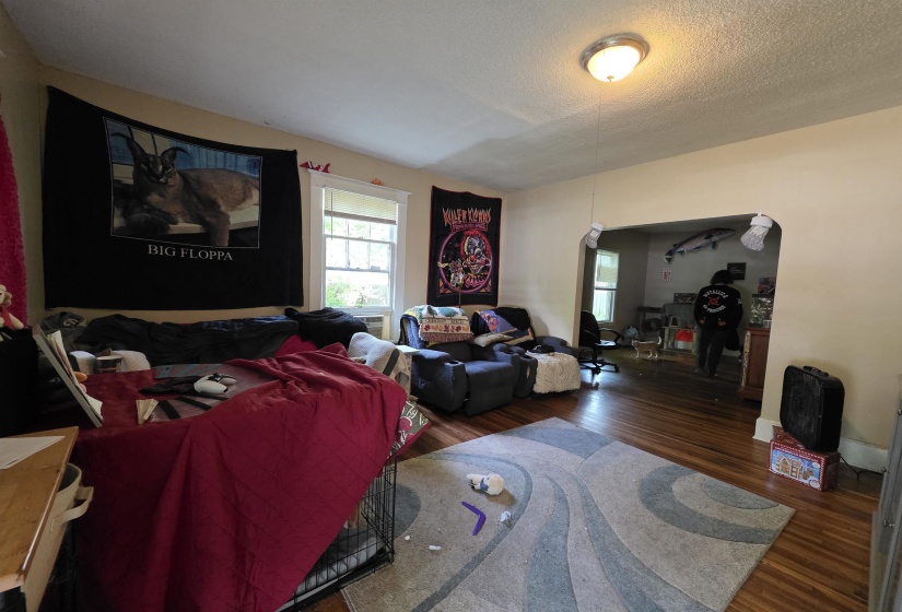 Living space with wood-finish flooring, light-toned walls, and a semi-flush mount ceiling fixture